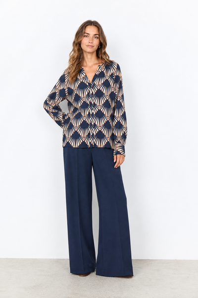 Geometric print blouse on a female model wearing navy pants