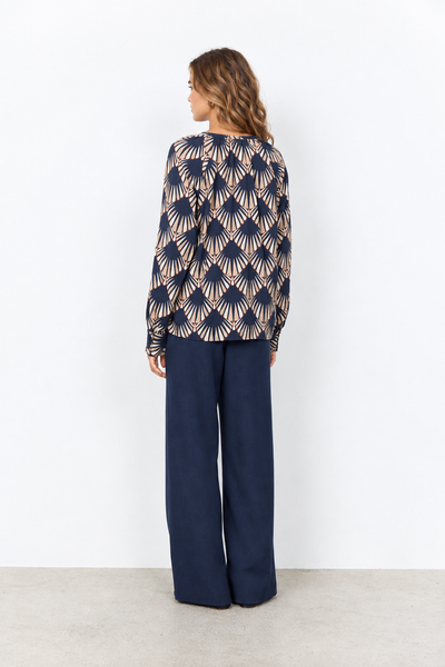 Geometric print blouse on a female model wearing navy pants